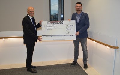 Der Vorstandsvorsitzender der KJF, Direktor Markus Mayer, nimmt den Spendengutschein über 500 Euro von Bernd Zimmerly vom Unternehmen Elektro Zimmerly entgegen (Foto: KJF/Ralf Beunink)